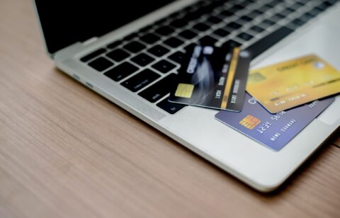 Laptop with multiple credit cards on the keyboard, representing online transactions or financial management.