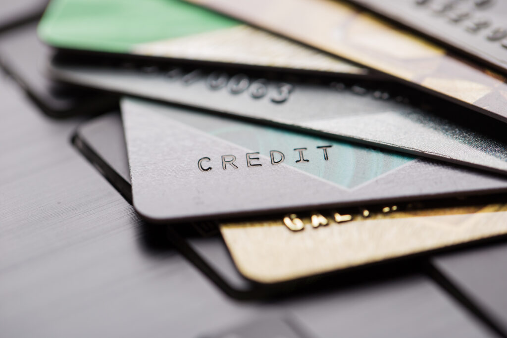 Several overlapping credit cards on a surface, shown in a blurred, close-up view