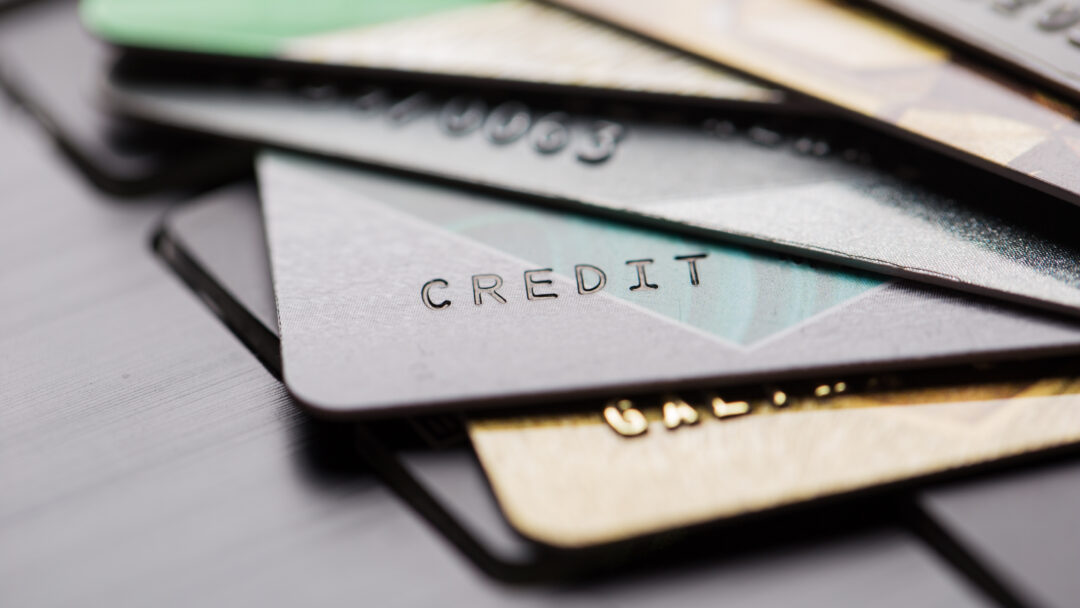 Several overlapping credit cards on a surface, shown in a blurred, close-up view