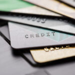Several overlapping credit cards on a surface, shown in a blurred, close-up view