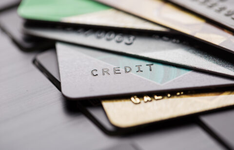 Several overlapping credit cards on a surface, shown in a blurred, close-up view