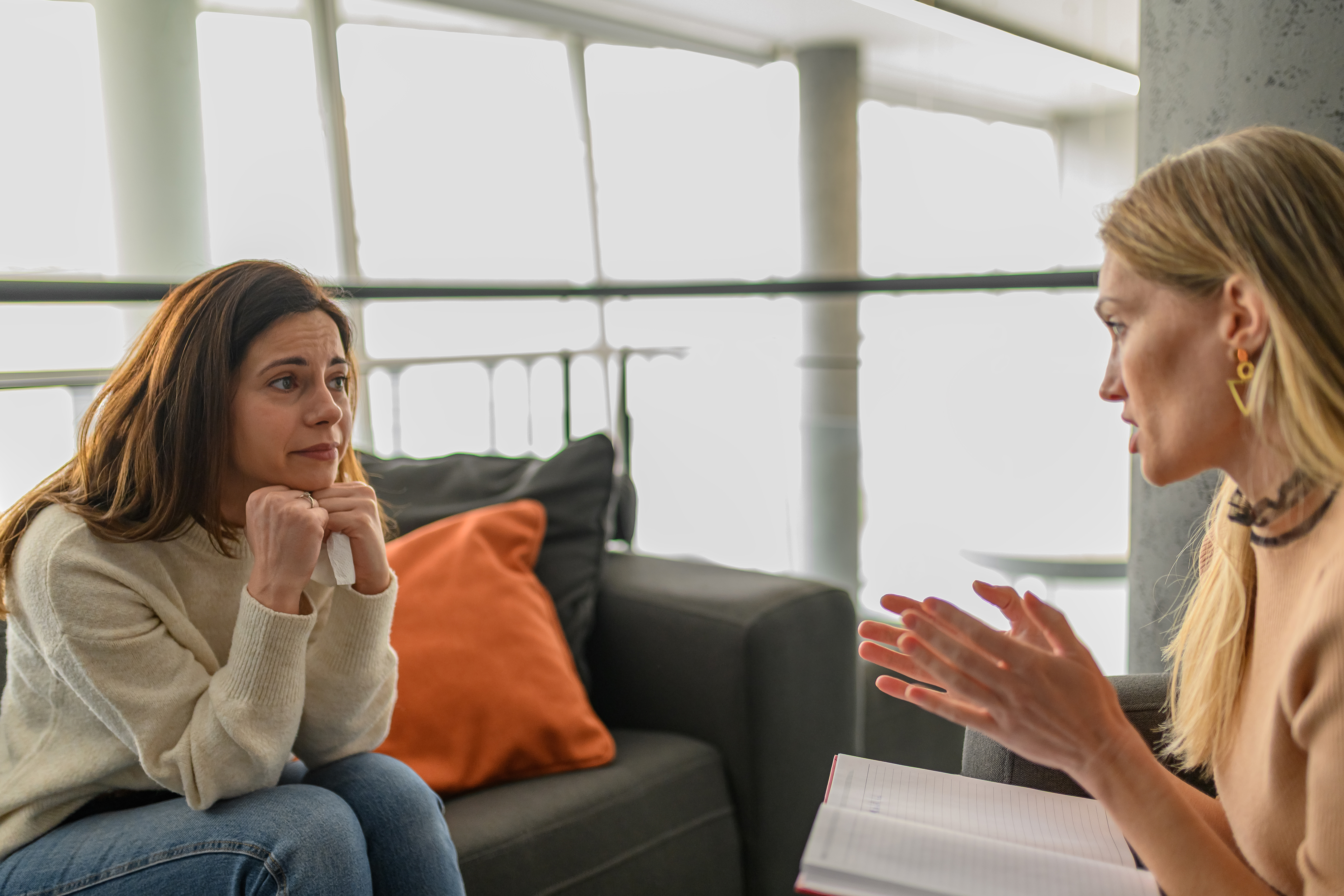 Woman receiving emotional support from a professional during a private conversation in an office setting.