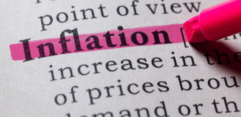 Close-up of the word “inflation” marked with a pink highlighter on a printed page.