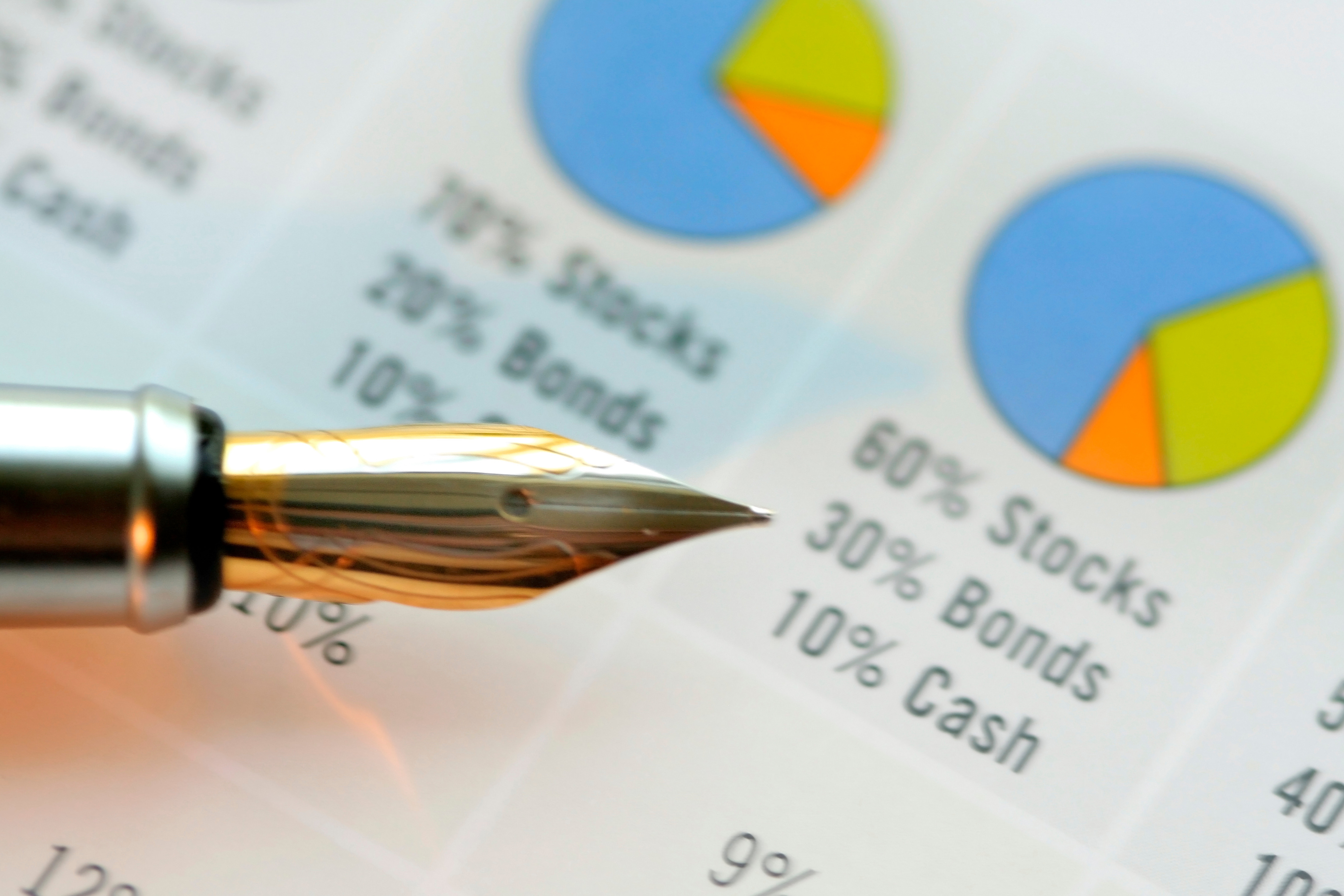 Close-up of a fountain pen resting on a financial chart showing stock, bond, and cash allocations.