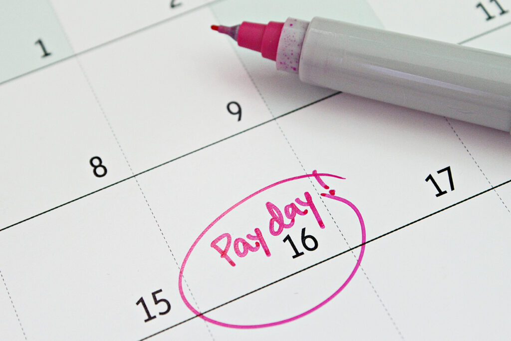 Close-up of a calendar showing the 16th marked as payday in pink marker.