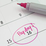 Close-up of a calendar showing the 16th marked as payday in pink marker.