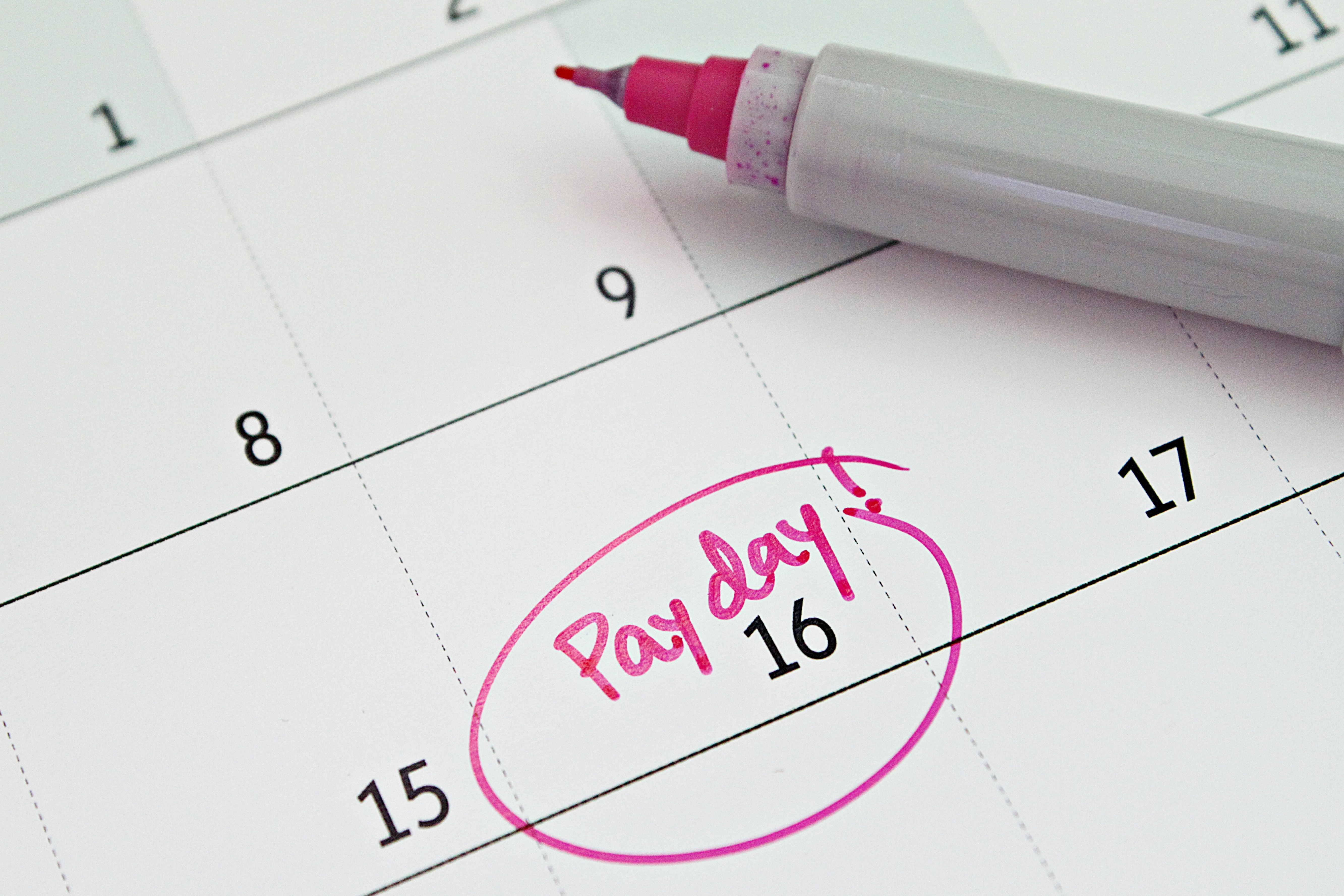 Close-up of a calendar showing the 16th marked as payday in pink marker.