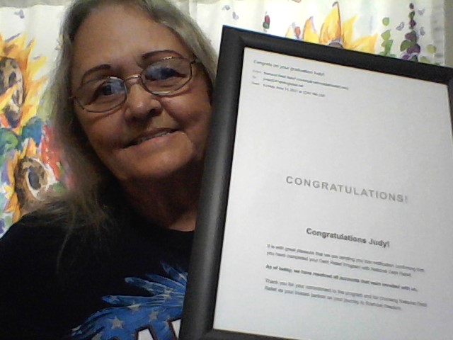 Smiling woman holding a framed congratulatory certificate