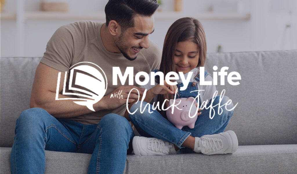 A father smiling as he helps his daughter put coins into a pink piggy bank, with the Money Life with Chuck Jaffe logo overlayed on the image.