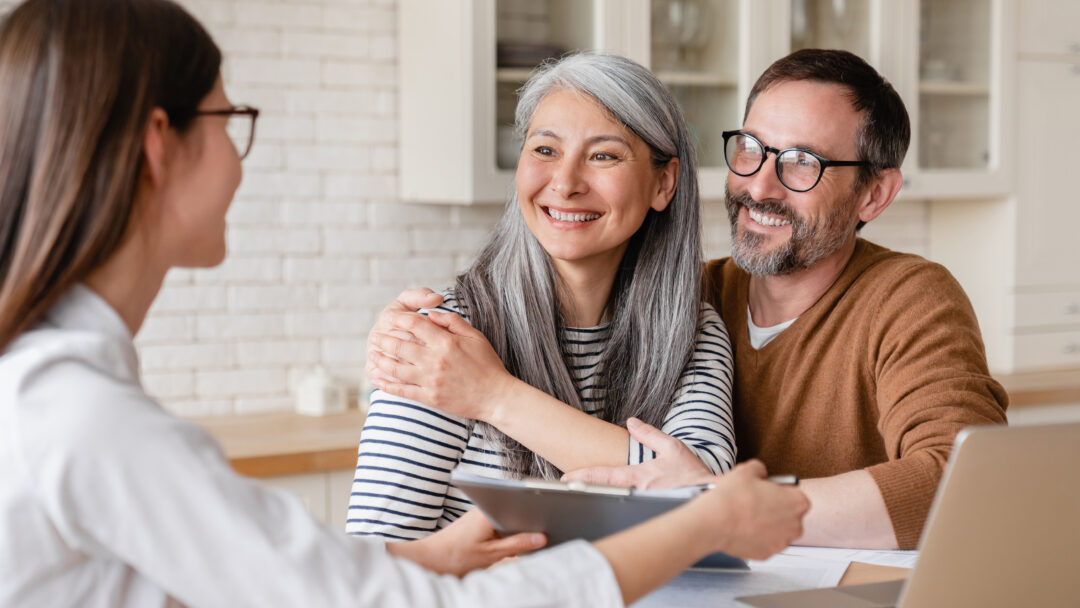 Smiling couple meeting with a financial professional at home.