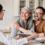 Smiling couple meeting with a financial professional at home.