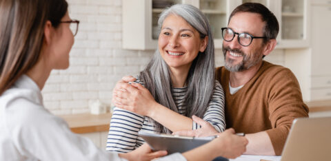 Smiling couple meeting with a financial professional at home.