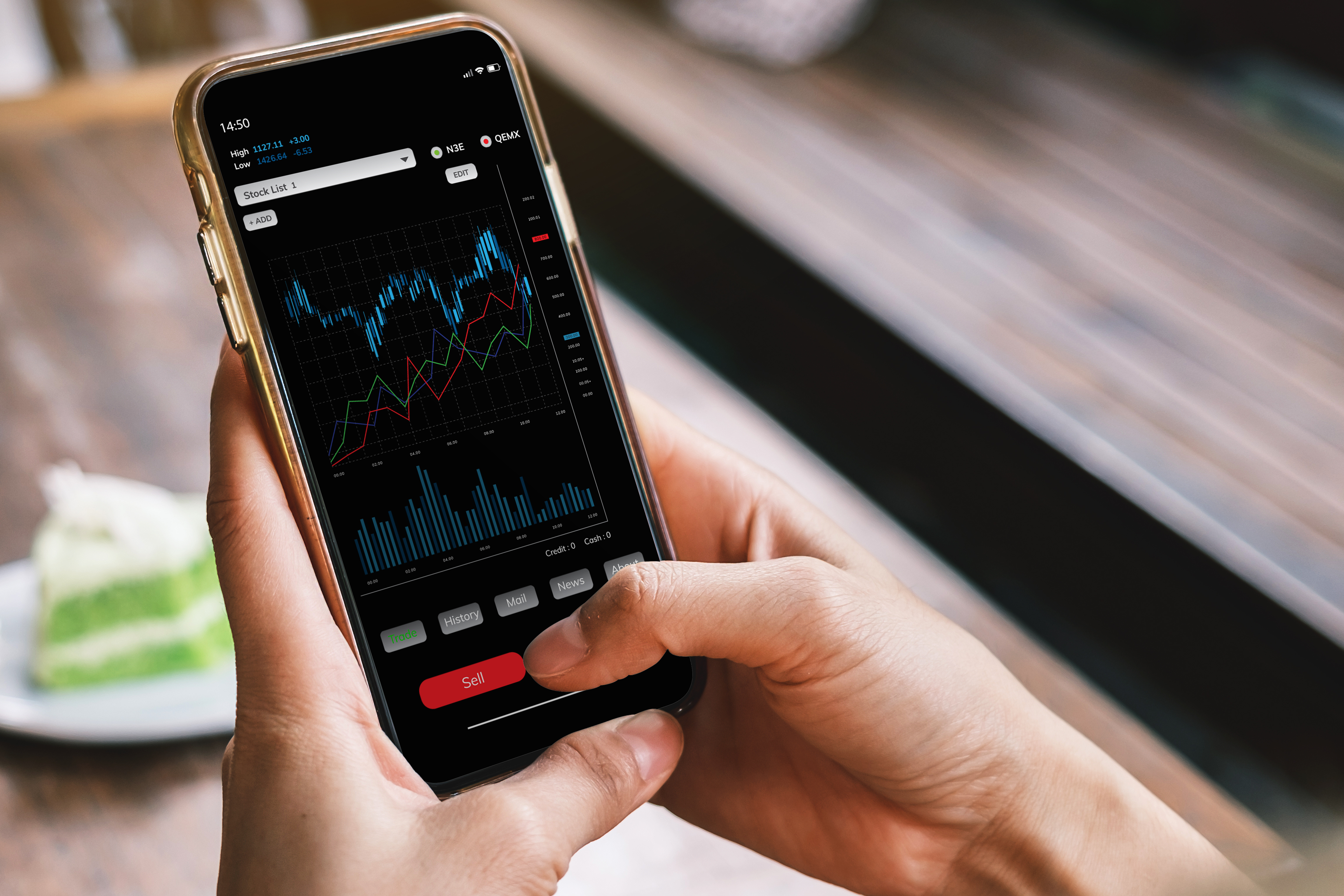 Person using a smartphone to view stock market charts and press the sell button.