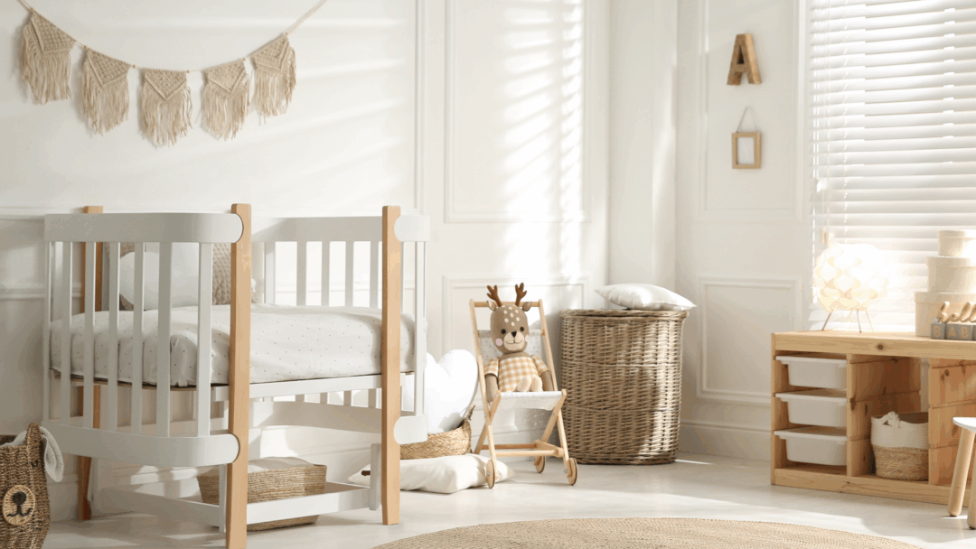 A bright nursery with a white crib, wicker baskets, a stuffed deer toy, and natural wood furniture.