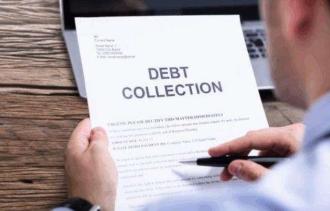 Person holding a debt collection notice with the words “Debt Collection” printed in large letters at the top.