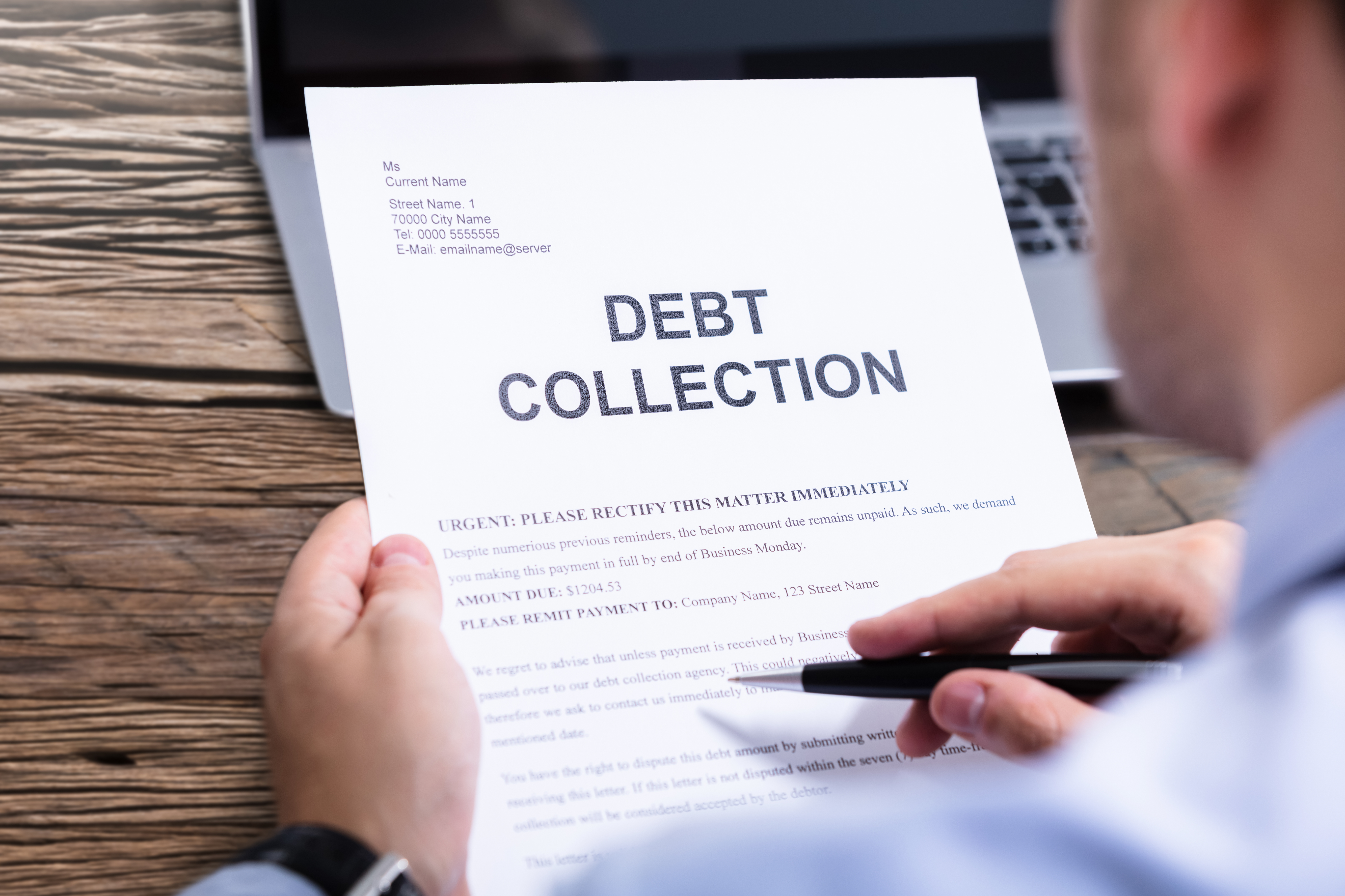 Person holding a debt collection notice with the words “Debt Collection” printed in large letters at the top.