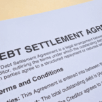 Close-up of a document titled “Debt Settlement Agreement” showing printed terms and conditions.