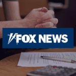 Clasped hands of a person wearing a military uniform resting above paperwork on a table, with a Fox News logo overlaid in the center.