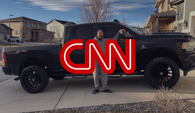 Person standing beside a large black pickup truck in a suburban driveway, with a red CNN logo overlaid on the image.