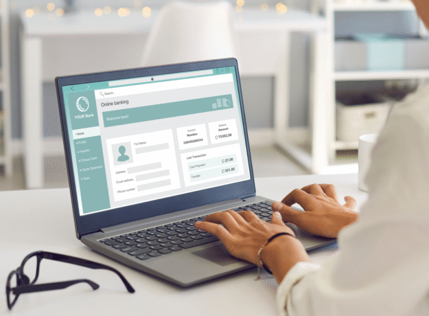 Person using a laptop to access an online banking account dashboard.