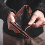 Person holding an open, empty wallet with no cash inside.