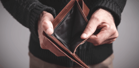 Person holding an open, empty wallet with no cash inside.