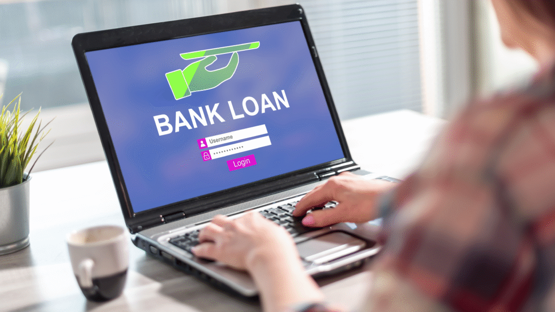 Person using a laptop displaying a bank loan login screen.