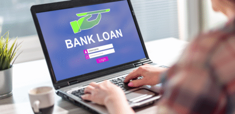 Person using a laptop displaying a bank loan login screen.