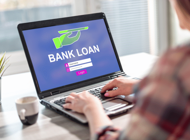 Person using a laptop displaying a bank loan login screen.