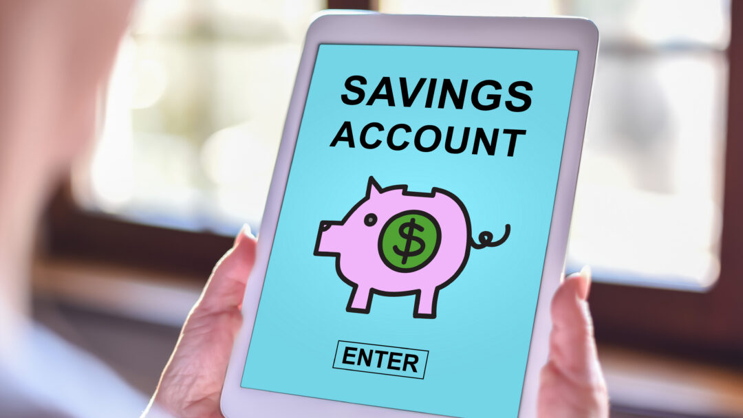Tablet screen displaying “Savings Account” with a piggy bank icon and enter button.