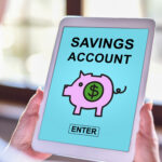 Tablet screen displaying “Savings Account” with a piggy bank icon and enter button.