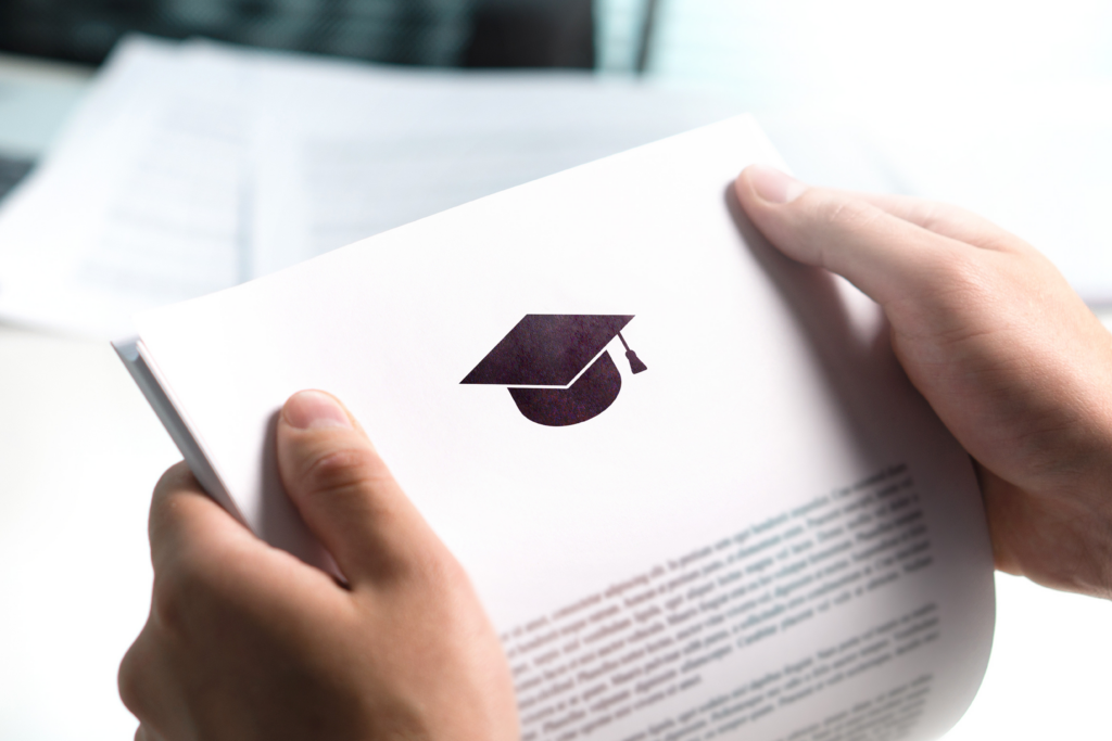 Hands holding a document with a graduation cap icon, representing student loan or education-related paperwork