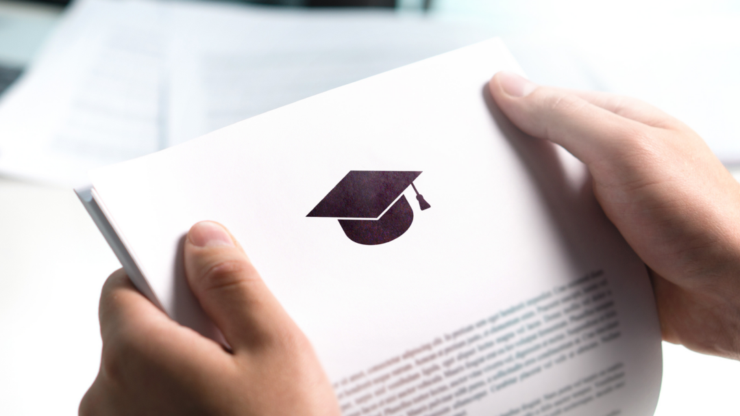 Hands holding a document with a graduation cap icon, representing student loan or education-related paperwork