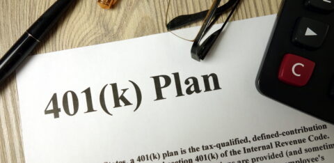 Document labeled “401(k) Plan” on a desk with a pen, eyeglasses, and calculator nearby.
