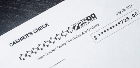 Close-up of a cashier’s check showing a payment amount of $725 with the date printed.