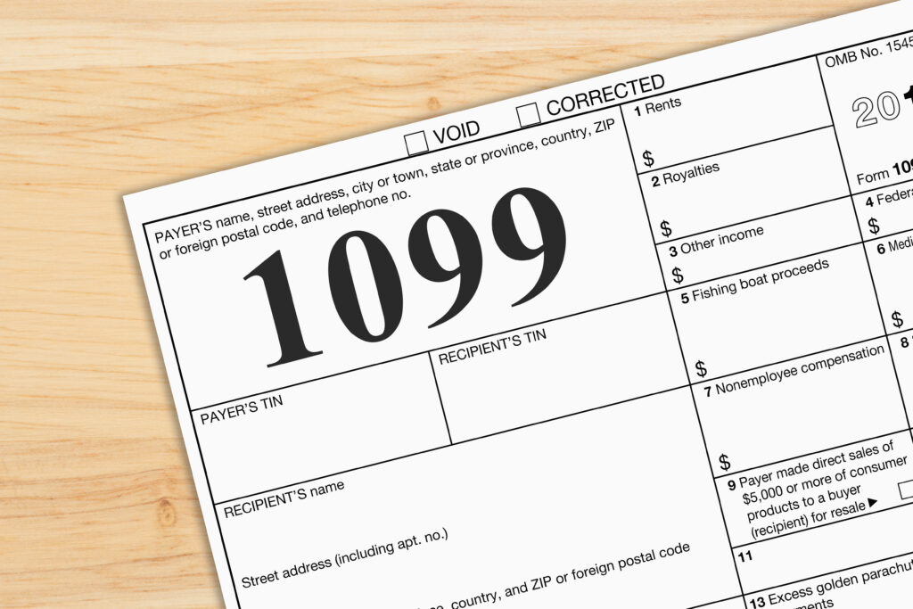 Close-up of a Form 1099 tax document on a wooden desk, representing income reporting and tax filing.