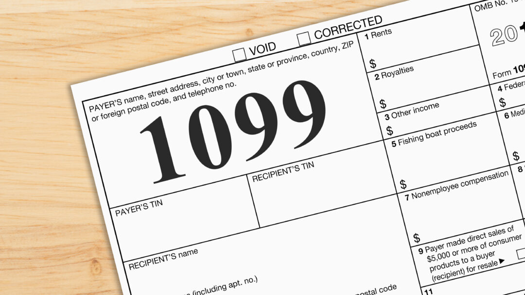 Close-up of a Form 1099 tax document on a wooden desk, representing income reporting and tax filing.