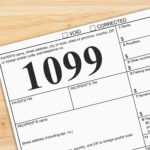 Close-up of a Form 1099 tax document on a wooden desk, representing income reporting and tax filing.
