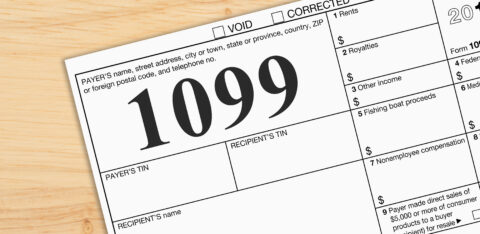 Close-up of a Form 1099 tax document on a wooden desk, representing income reporting and tax filing.