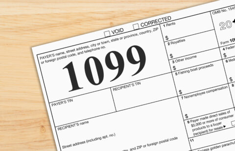 Close-up of a Form 1099 tax document on a wooden desk, representing income reporting and tax filing.