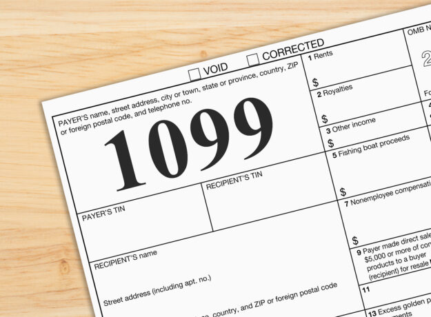 Close-up of a Form 1099 tax document on a wooden desk, representing income reporting and tax filing.