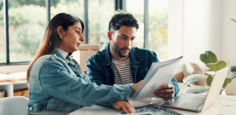 House, documents and couple with laptop, discussion and planning finance with savings. Assets, paperwork and man with woman, pc and expenses with budget, mortgage payment or bills with life insurance