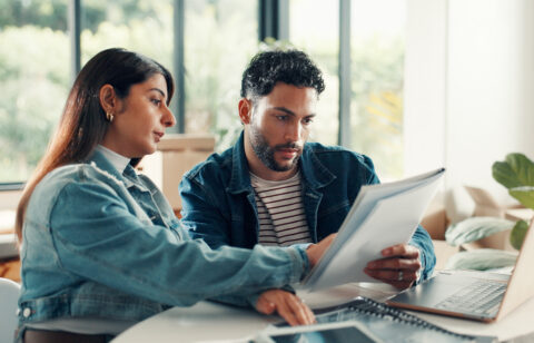 House, documents and couple with laptop, discussion and planning finance with savings. Assets, paperwork and man with woman, pc and expenses with budget, mortgage payment or bills with life insurance
