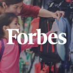 Mother and young daughter shopping for backpacks together during back-to-school season