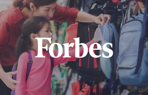 Mother and young daughter shopping for backpacks together during back-to-school season