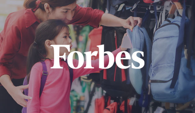 Mother and young daughter shopping for backpacks together during back-to-school season