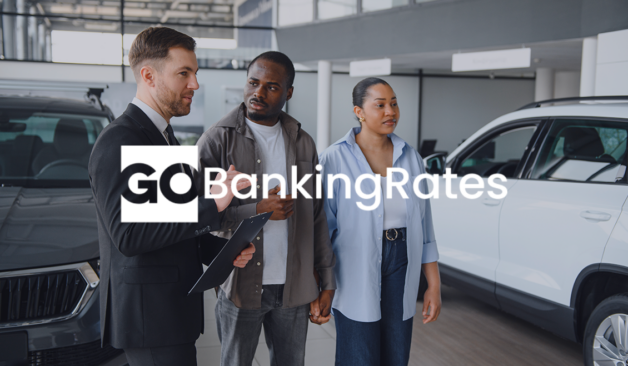 Car dealership scene with a salesperson showing a vehicle to two customers with GOBankingRates image text.