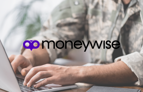 Person in military uniform typing on a laptop at a desk with the Moneywise logo displayed prominently in the center.