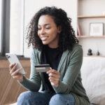 Woman holding credit card and using smartphone at home, businesswoman shopping online, e commerce, internet banking, spending money, working from home concept