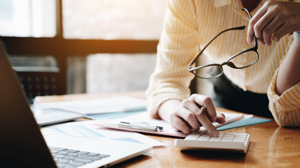 Close up Business woman using calculator and laptop for do math